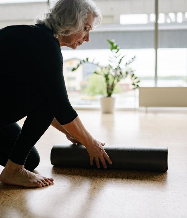 Woman performing a graceful balance exercise in a calm setting.